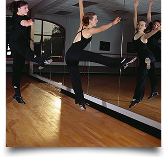 Dancer and instructor jumping in studio